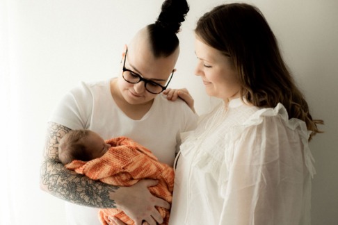 Aliisa ja Essi pitelevät vauvaansa. Kuva: @tanjaruotiphotography